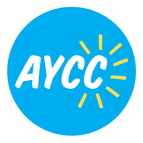 AYCC logo. White text reading AYCC in a blue circle, yellow lines spike out from the text like sun rays.